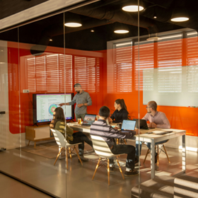 동료들이 회의실에서 만나 차트를 검토합니다.