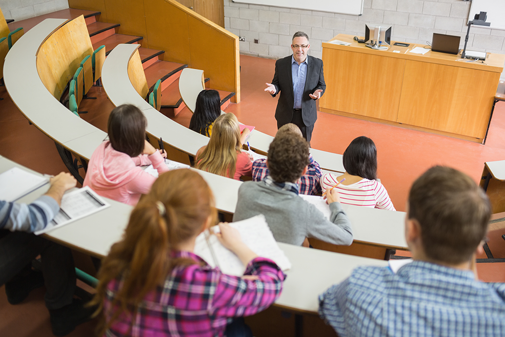 Un profesor enseñando estadística a una clase llena de estudiantes universitarios.